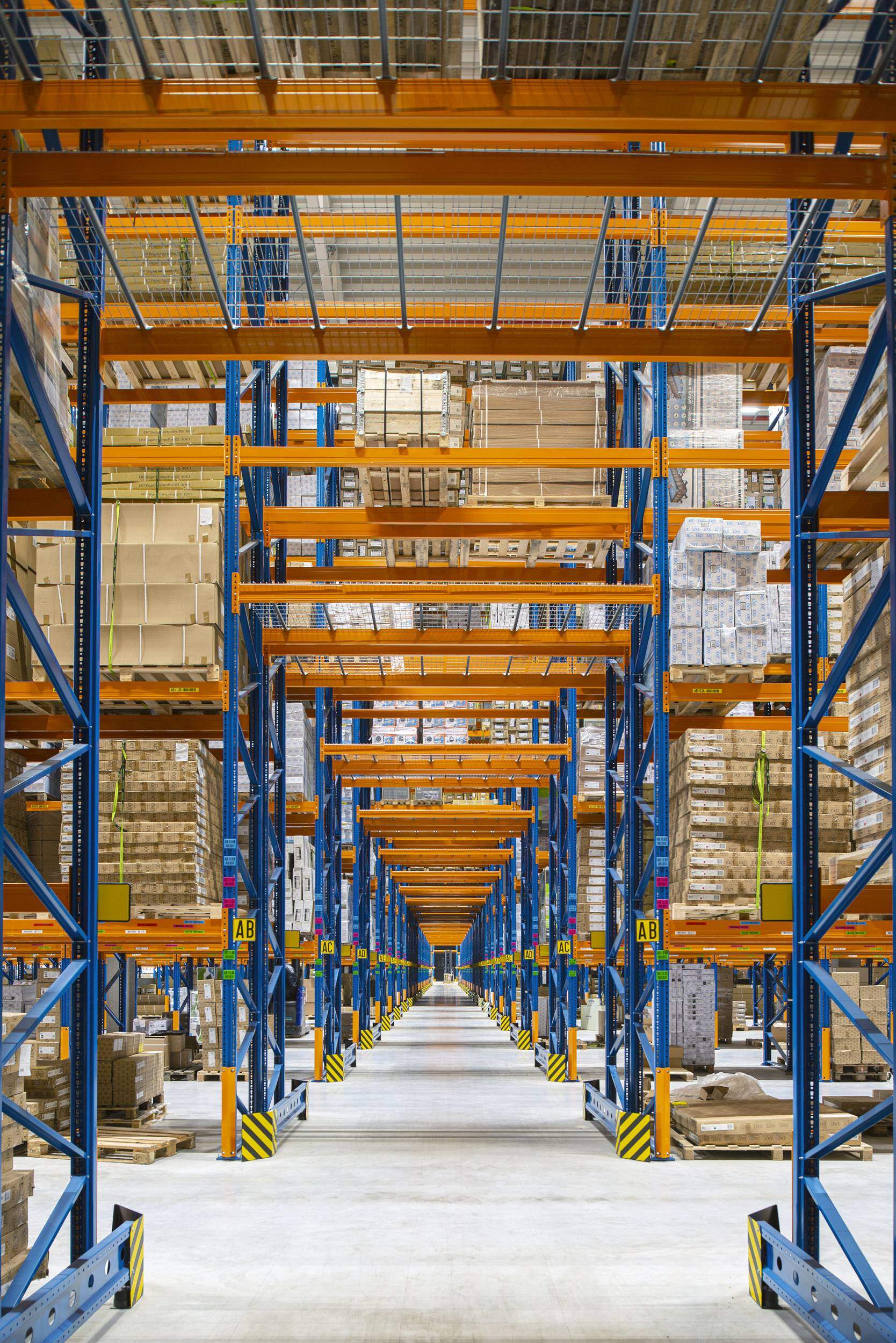 Hochregale in einem Logistikzentrum, die mit Beschriftungen und automatischen Lagereinrichtungen ausgestattet sind, um eine schnelle Warenabwicklung zu gewährleisten
