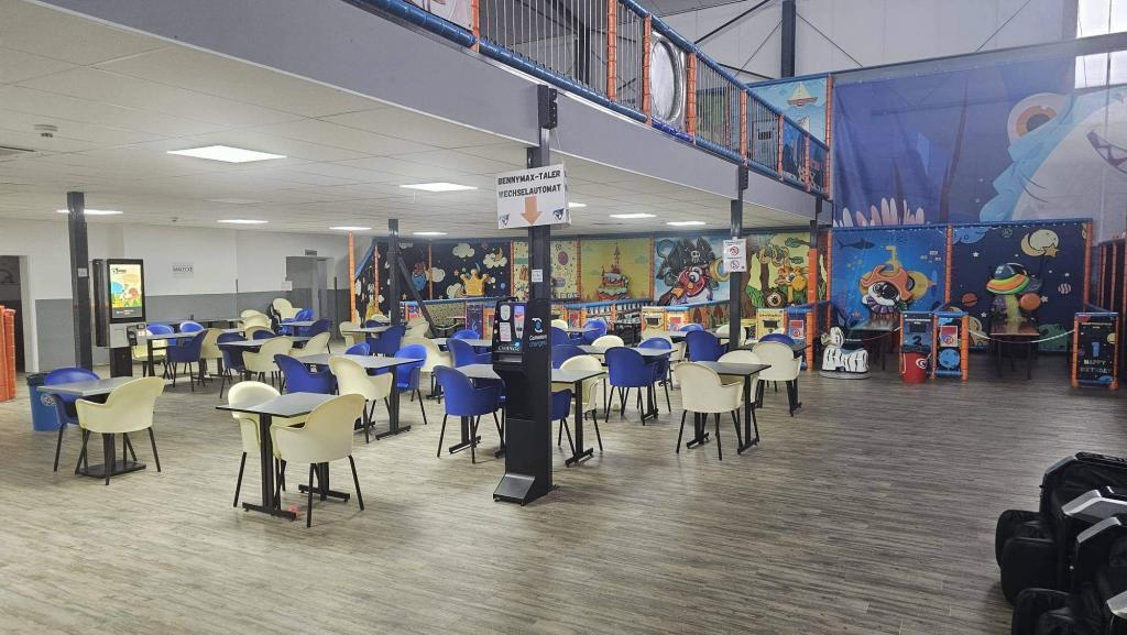 Moderne Bistroebene mit integrierter Lagerbühne in einem Indoorspielplatz.